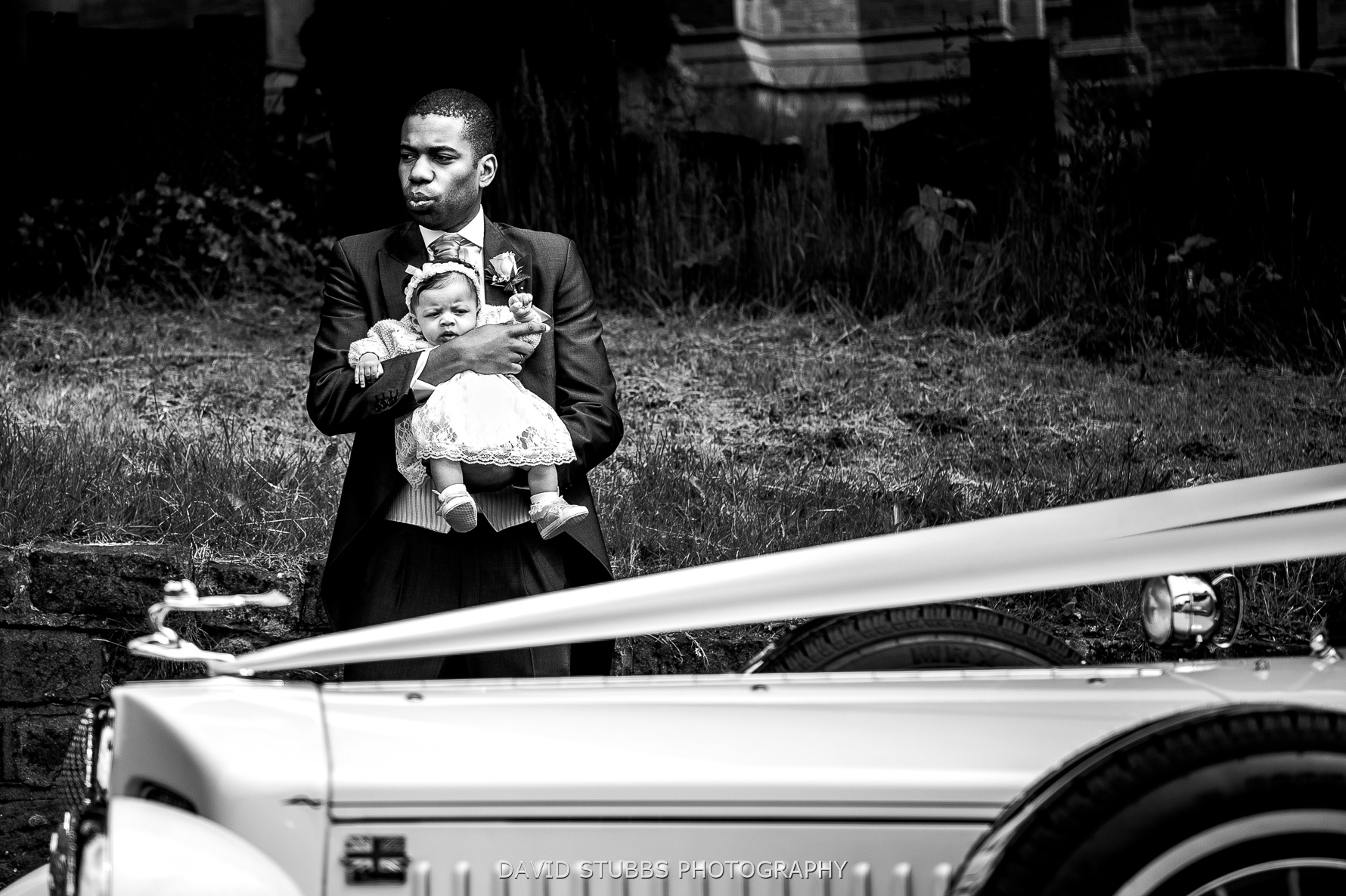 kid by wedding car black and white