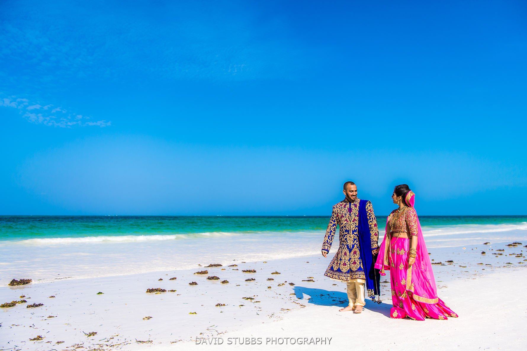 newlyweds walking along the beach