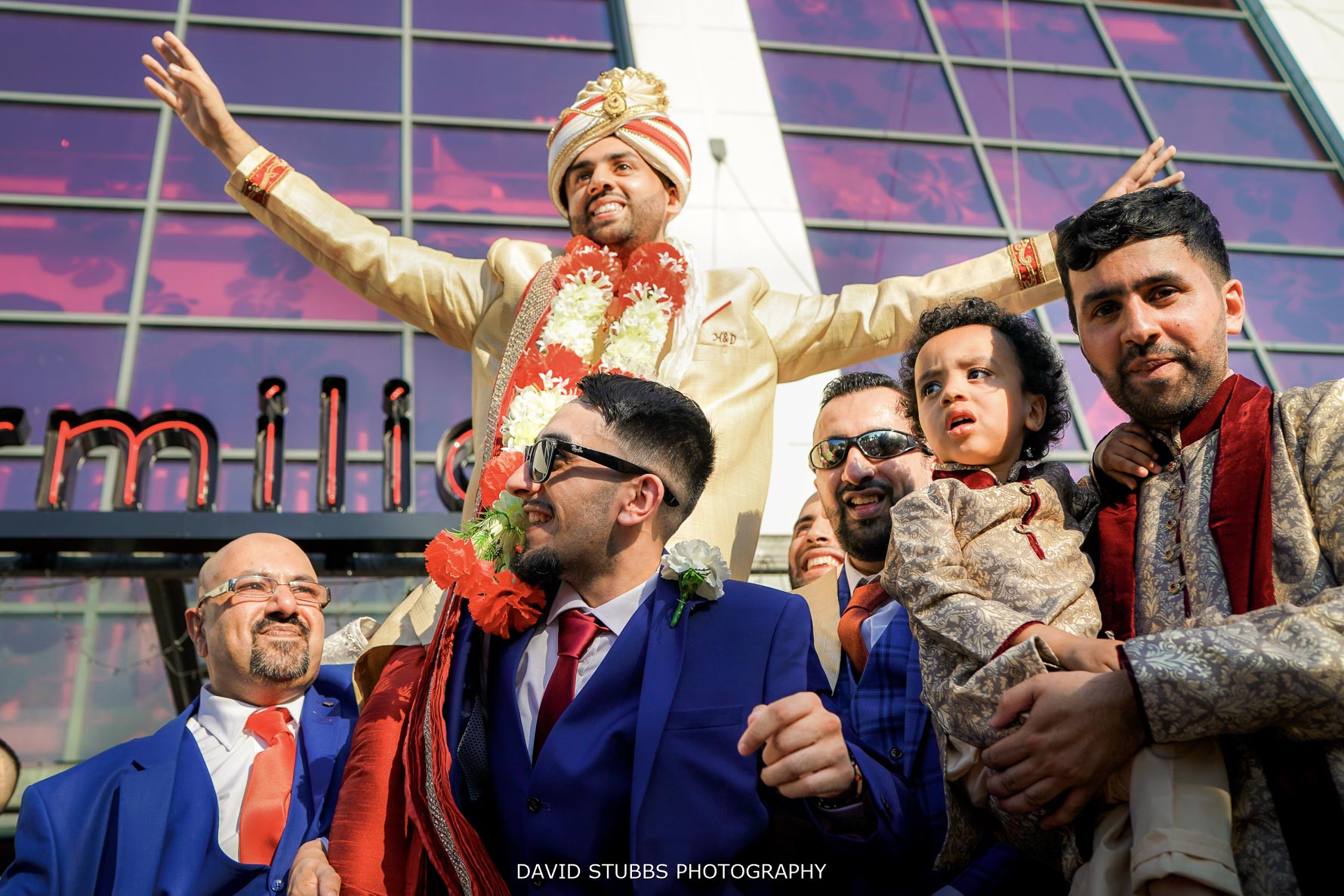 low angle of groom being held above all the groomsmen